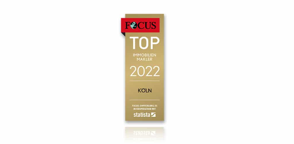 Eine gold-weiße Auszeichnungsplakette mit dem Focus-Logo oben und der Aufschrift Top Immobilien Makler 2022 Köln sowie den Logos von Focus und Statista unten.
